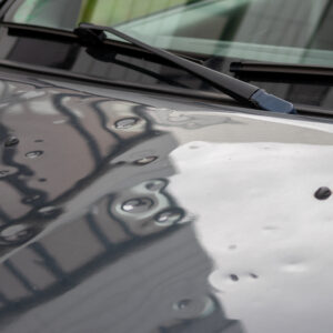 Car engine hood with many hail damage dents show the forces of n